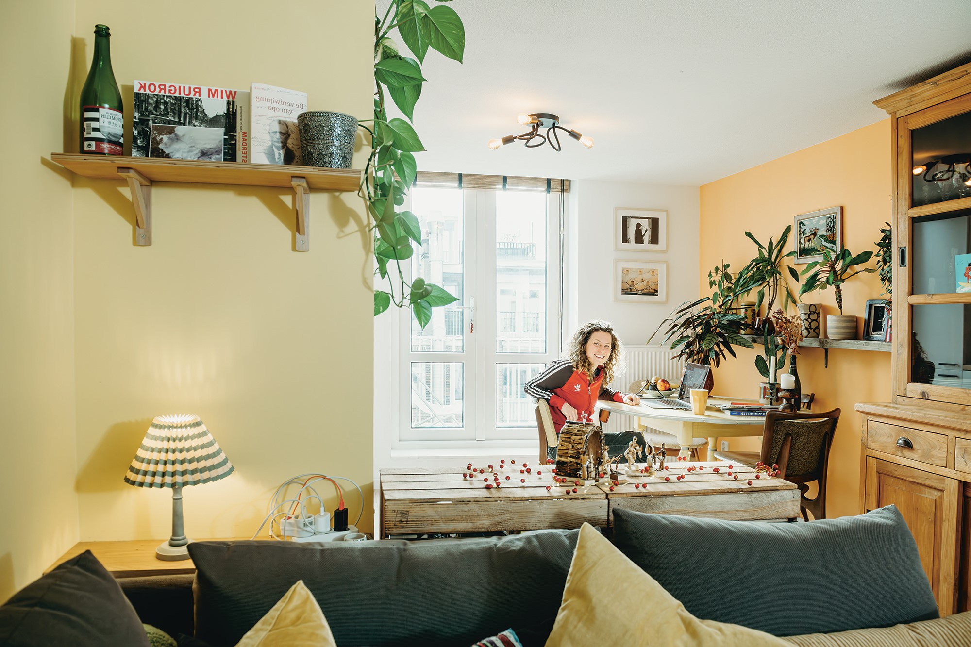 Jonge vrouw met krullen in haar huiskamer op stoel